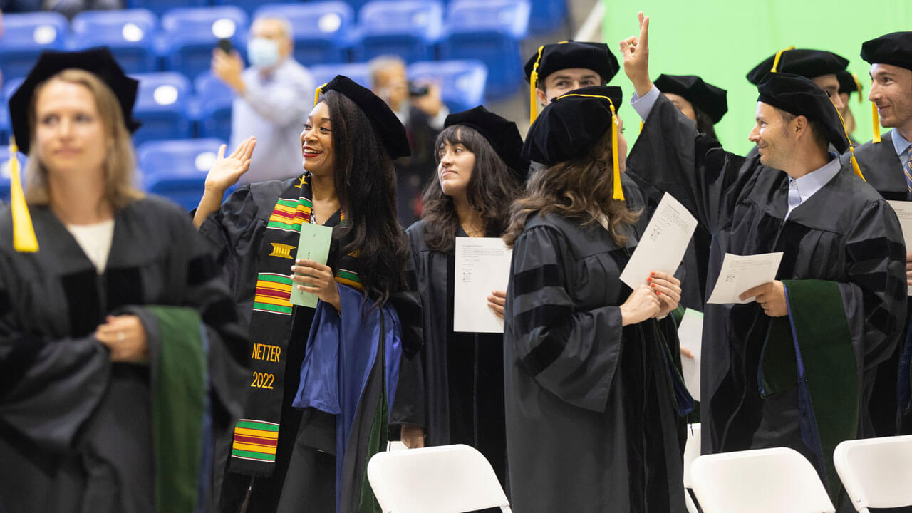 Medical graduates smile and wave in the commencement lineup