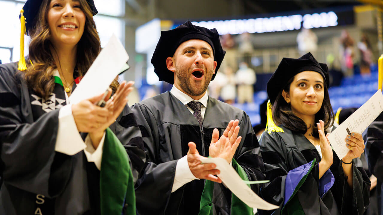 Group of medical graduate students applaud and cheer during commencement